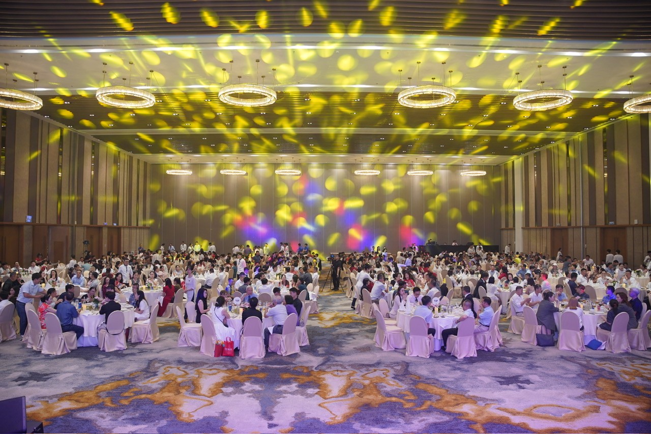 A large group of people sitting at tables in a room 
Description automatically generated